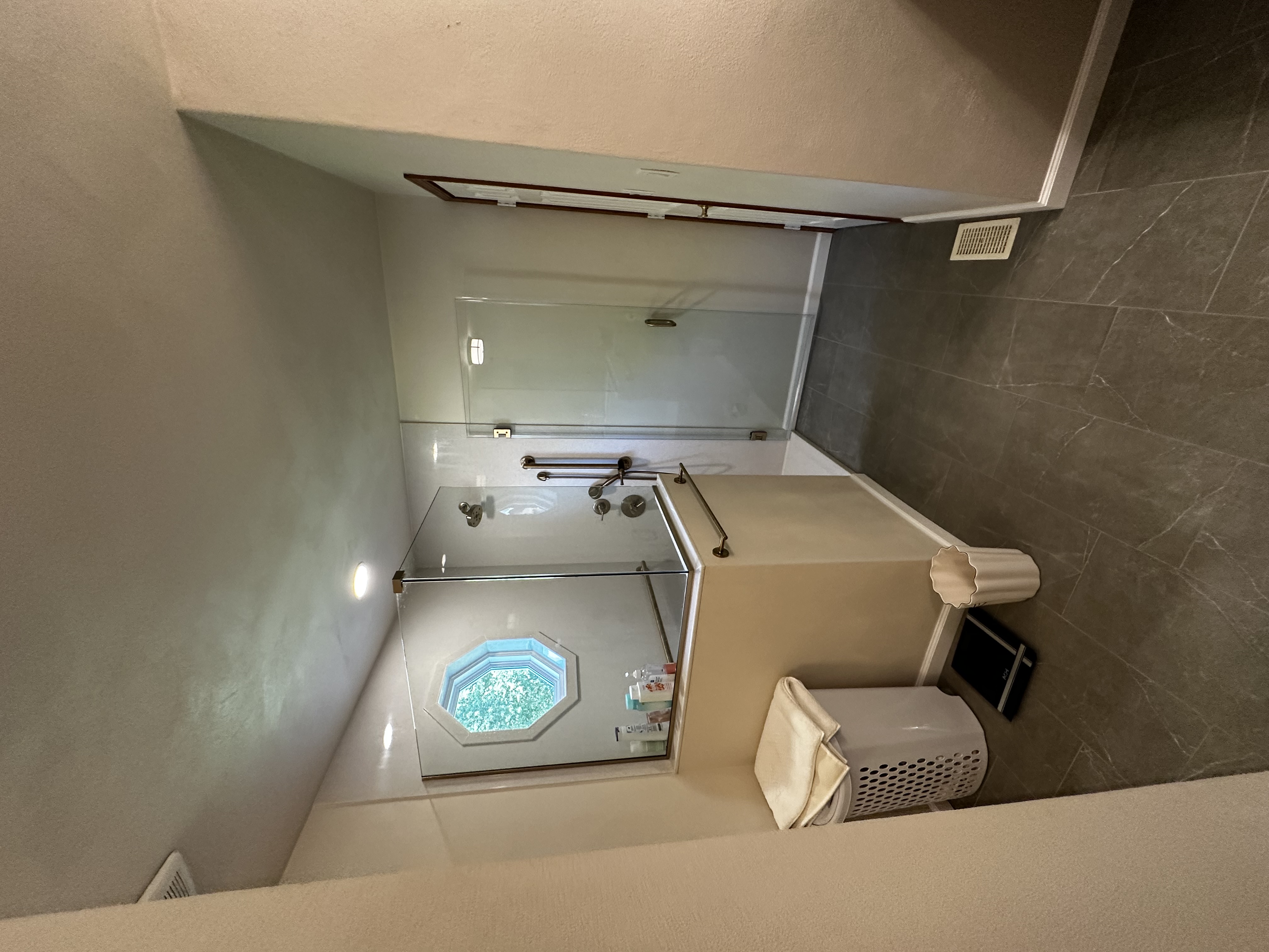 Completed custom shower with Onyx wall panels, detailed window surround, and gray tile flooring